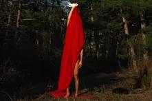 Person standing in the nature, covered with red fabric