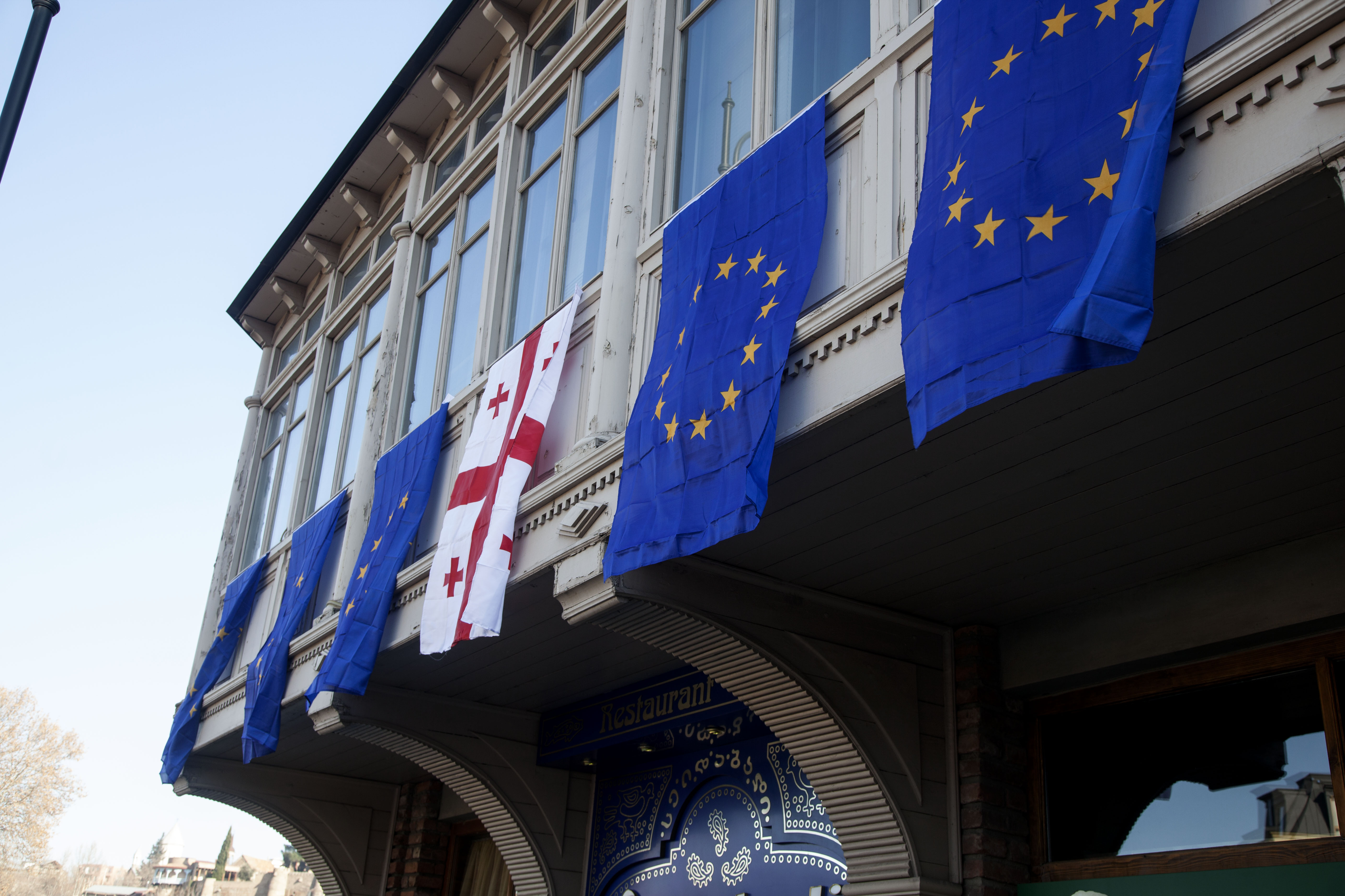 Georgian and EU flags hanging on the old building in Tbilisi
