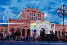 An evening scene featuring people in front of an illuminated building in the Armenian capital, Yerevan.