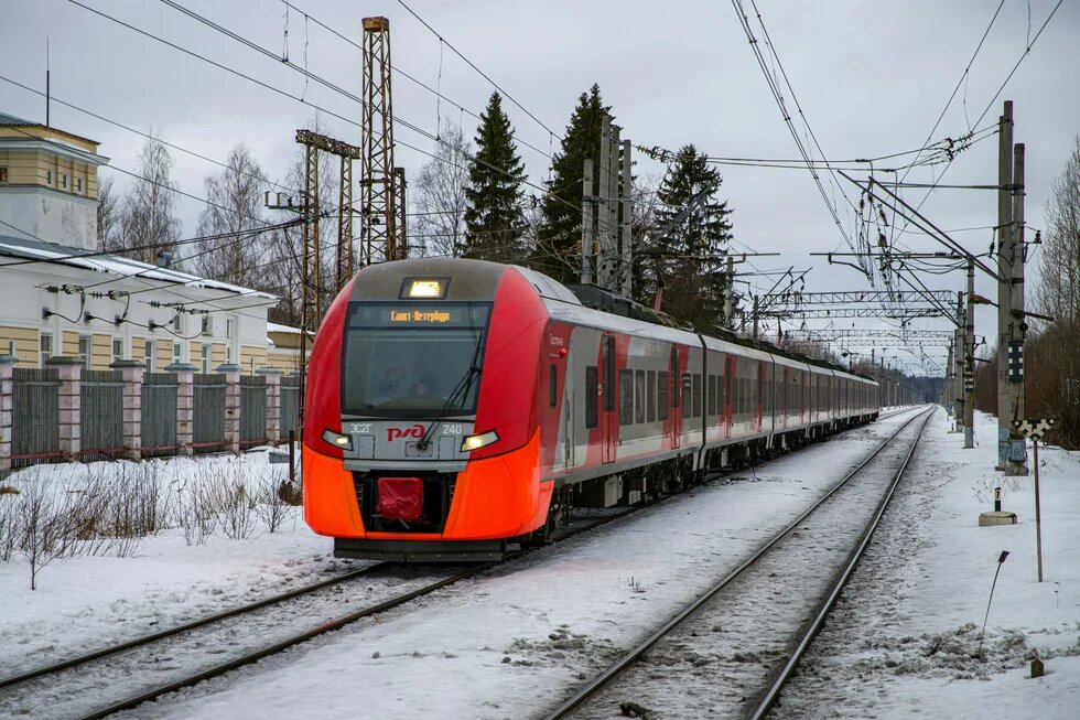 Ein roter und silberner Zug, der über Bahngleise fährt.